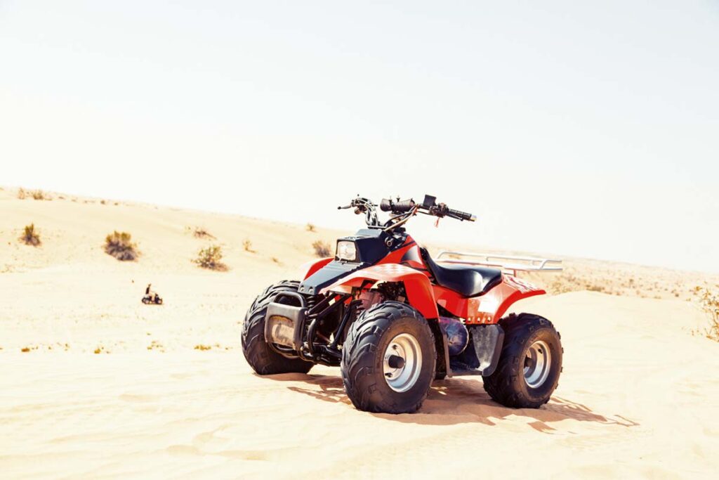 Red Quad Bike on Sand Dune