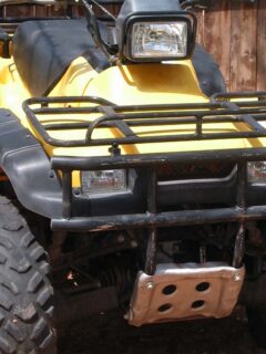 Yellow ATV Quad Parked By Fence