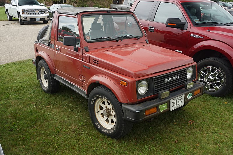 Red 1987 Suzuki Samurai on Grass