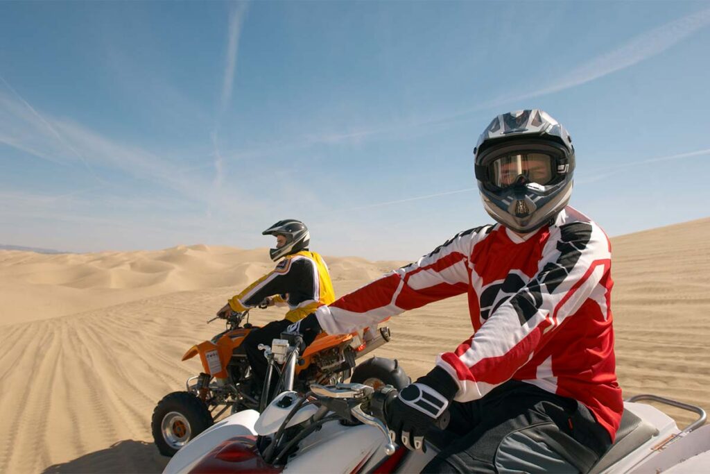 Riding Quad Bikes Over Desert Sand