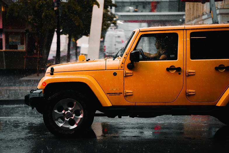 Yellow Jeep Wrangler Unlimited in Rain