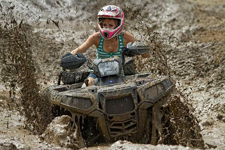 Woman Riding Off-Road ATV in Mud