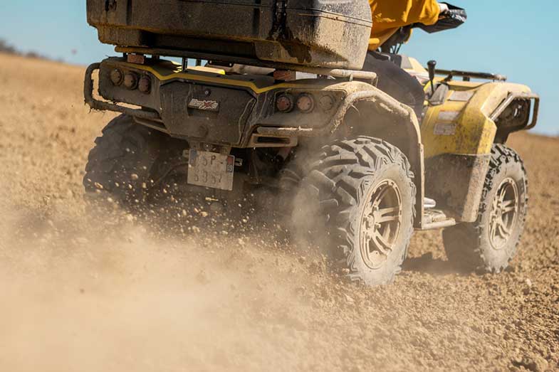 Yellow and Black ATV Driving on Rocky Terrain