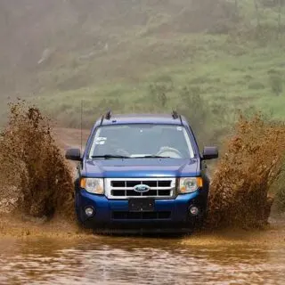 Blue Car Driving Through Mud