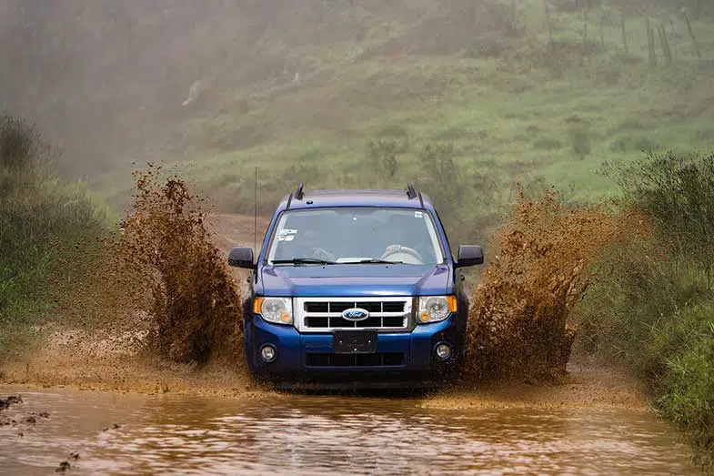 Blue Car Driving Through Mud