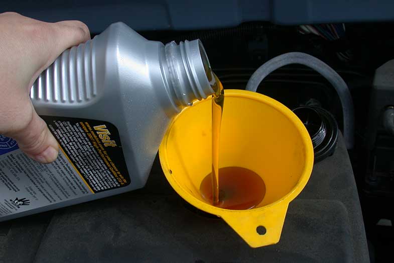 Recharge d'huile moteur avec entonnoir jaune