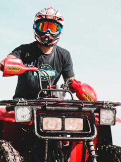 Person with Helmet and Goggles Riding Red ATV