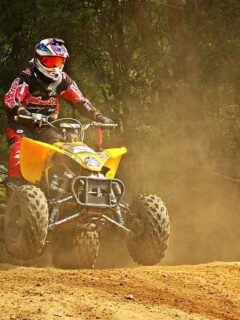 Yellow ATV Riding on Dusty Motocross Track