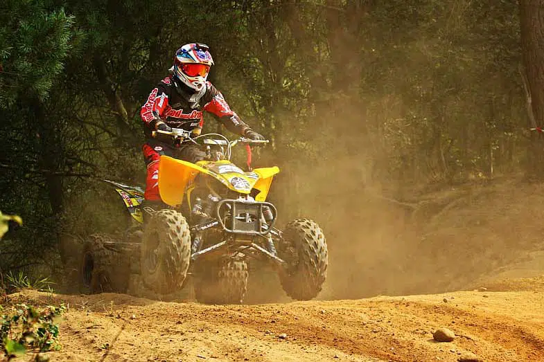 Yellow ATV Riding on Dusty Motocross Track