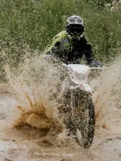 Dirt Bike Rider Splashing Through Muddy Water