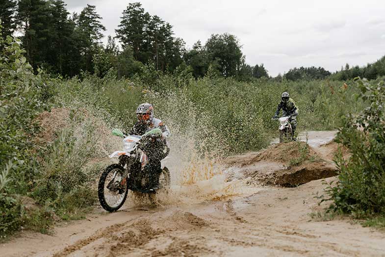 Dirt Bike Riding Through Muddy Trail