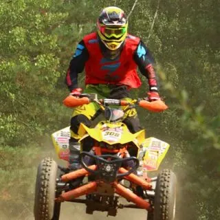 ATV Rider with Red Shirt Driving Yellow Quad