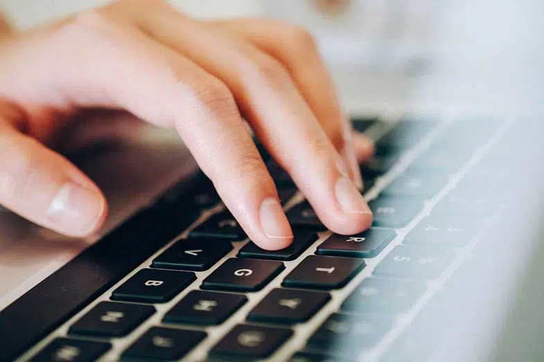 Person Typing on Laptop Computer Keyboard