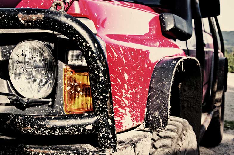 Red Off-Road Car Covered in Mud