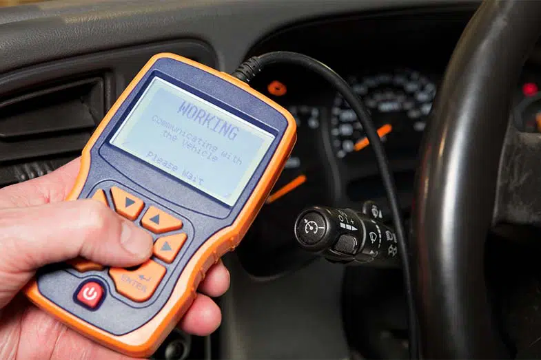 Mechanic Holding OBD Scanner Near SUV Dashboard