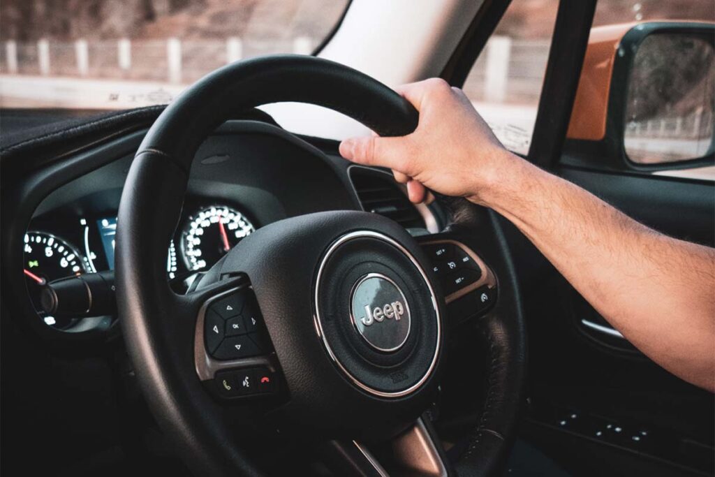 Person's Hand on Jeep Steering Wheel