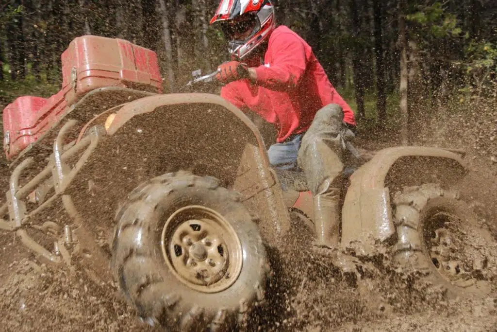 Riding Red ATV Through Muddy Water