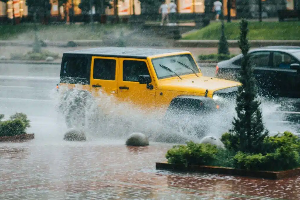 Yellow Jeep Driving Through Flooded Street
