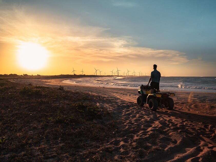 Man Riding ATV on the Beach During Sunset