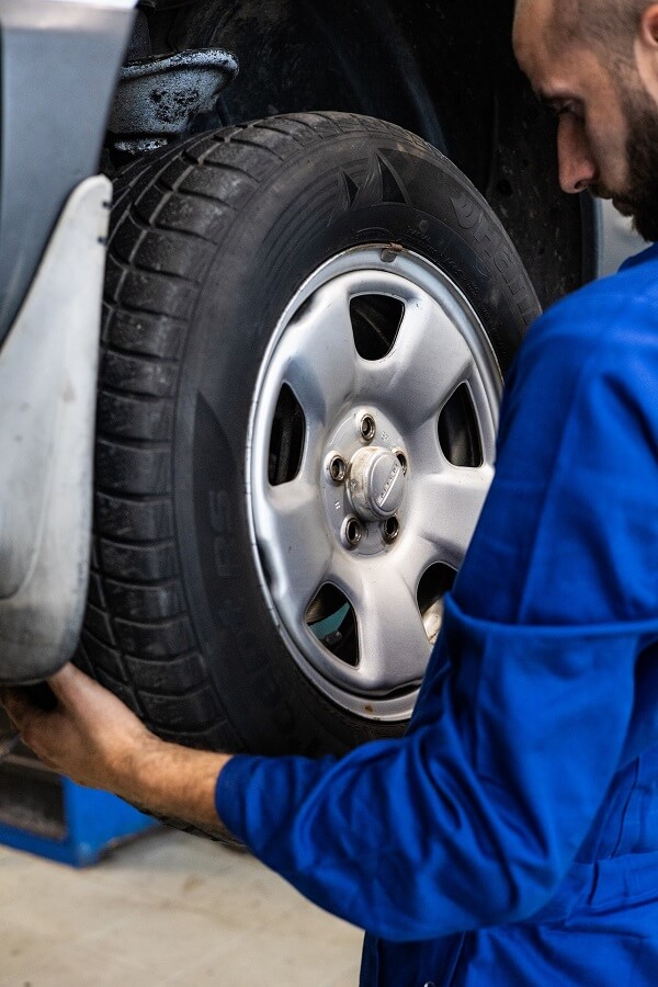 Mechanic Inspecting Car Tire