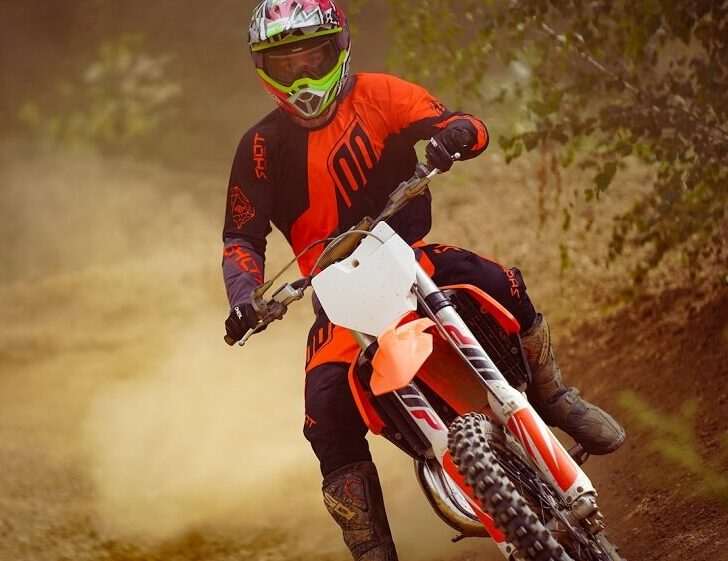 Person Wearing a Helmet Riding a Dirt Bike Motorcycle