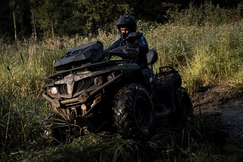 Person Riding ATV Quad Through Mud