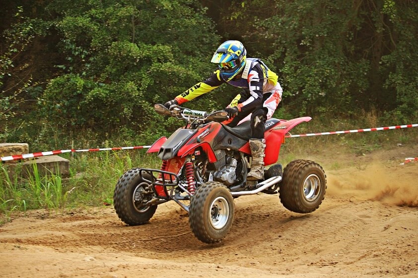 Riding Red ATV Quad Bike on a Sandy Track