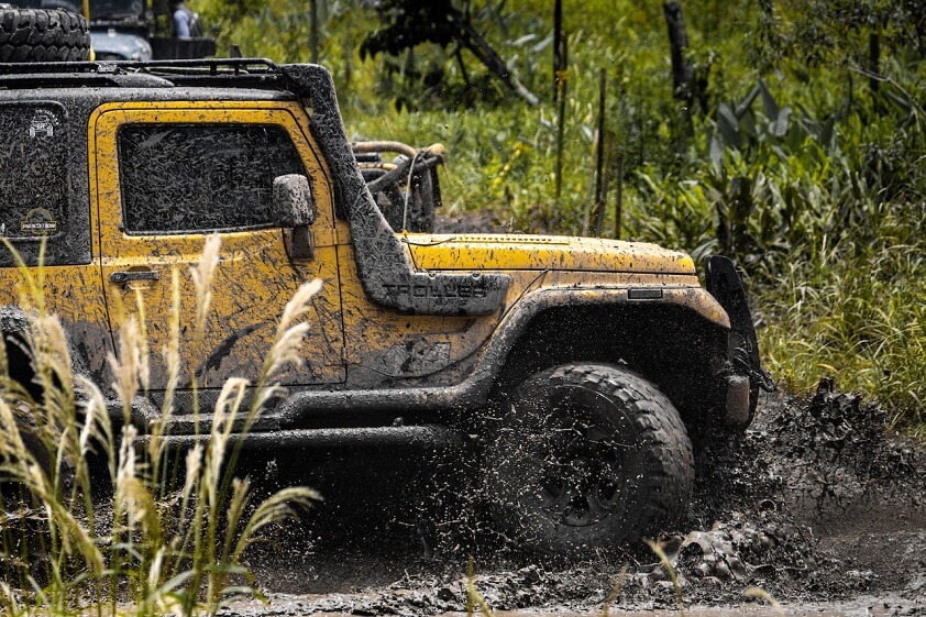 Yellow Jeep Off-Road in Muddy Terrain