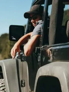 Man Sitting Inside Jeep Looking Out Window