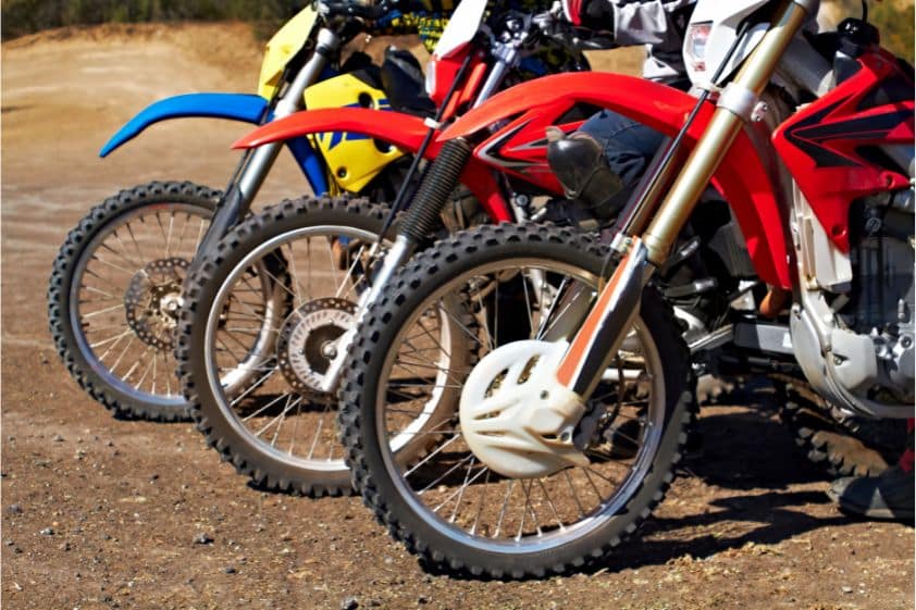 Three Dirt Bikes Standing in a Row