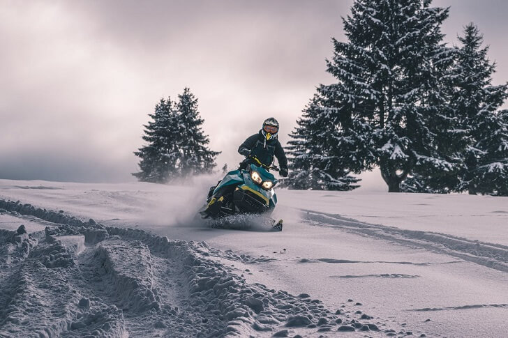 Person Riding Snowmobile Downhill