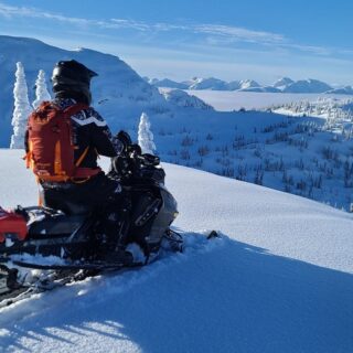 Person Riding Snowmobile on a Winter Hill