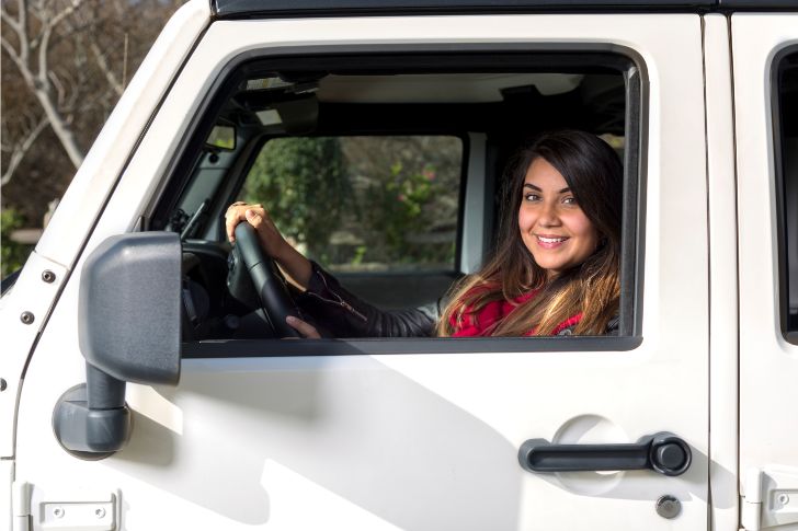 Smiling Woman Driving White Jeep